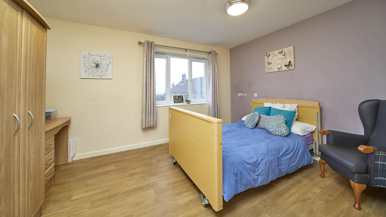 Large bedroom with bed, chair and wardrobes