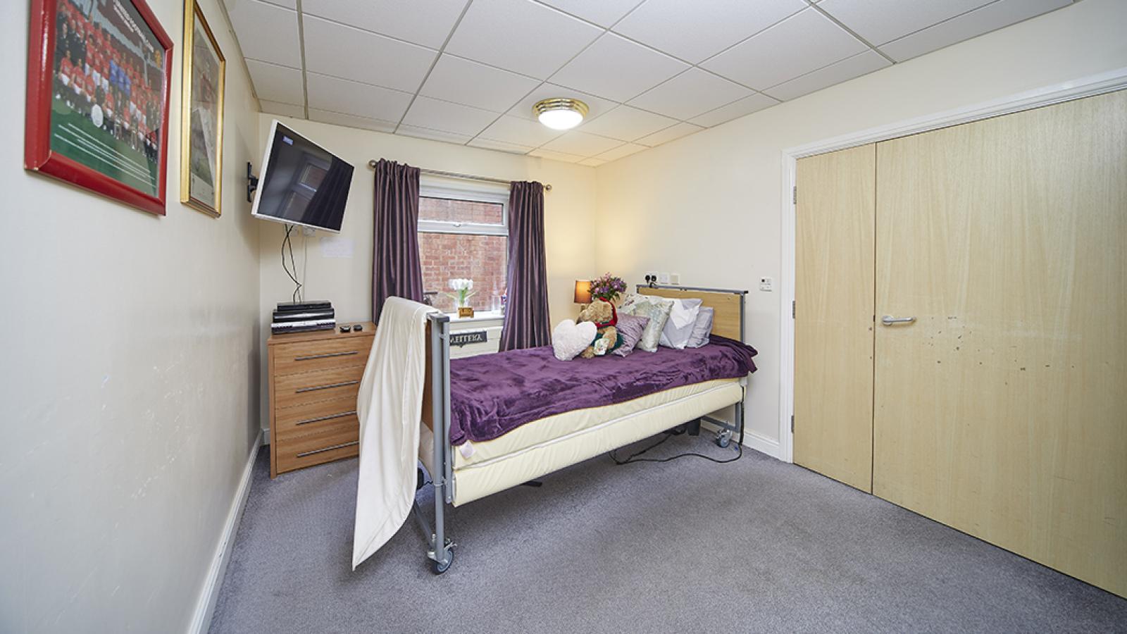 Willowbeck bedroom with bed, TV and wardrobe