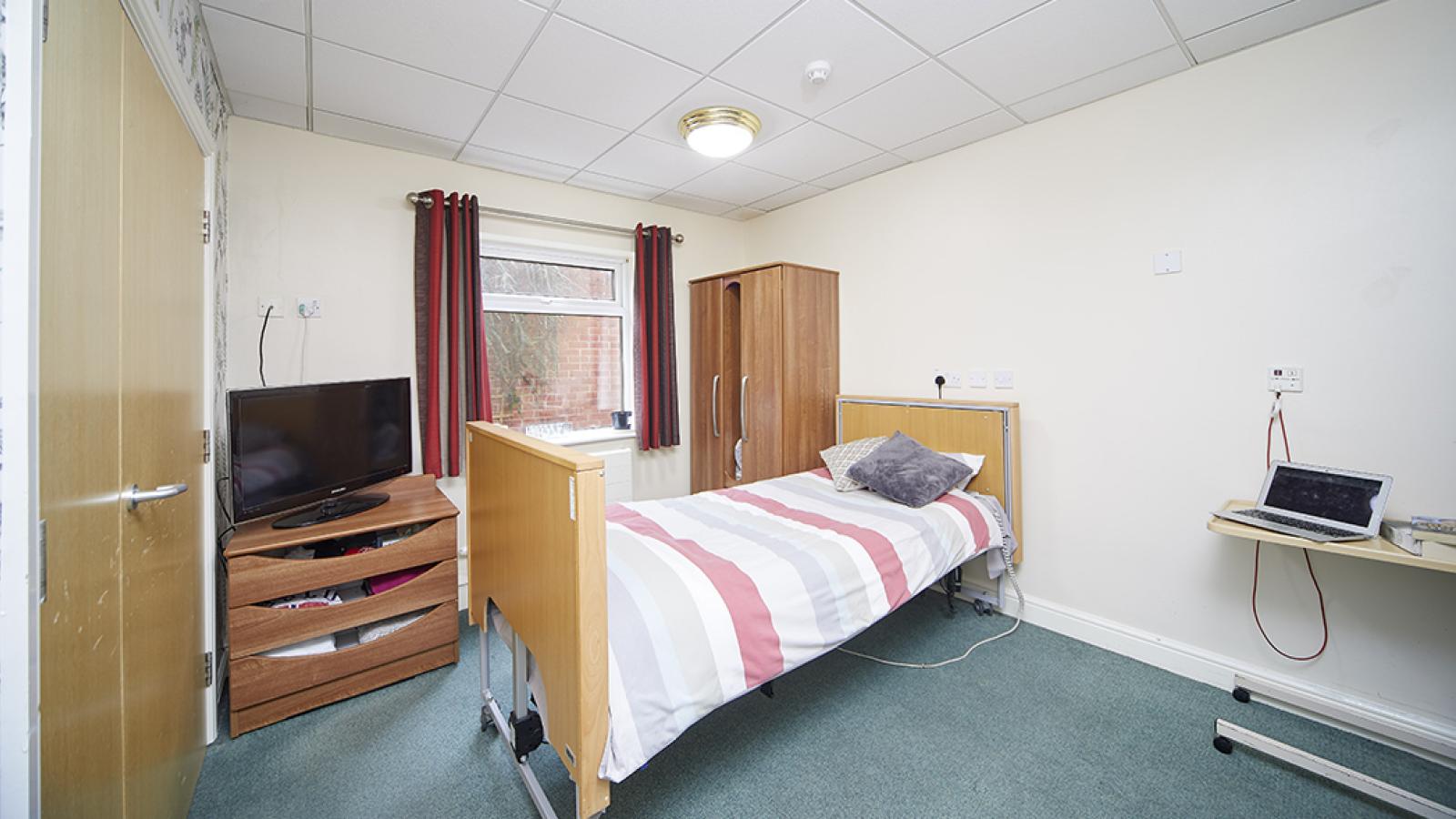 Willowbeck bedroom with bed, TV and wardrobe in
