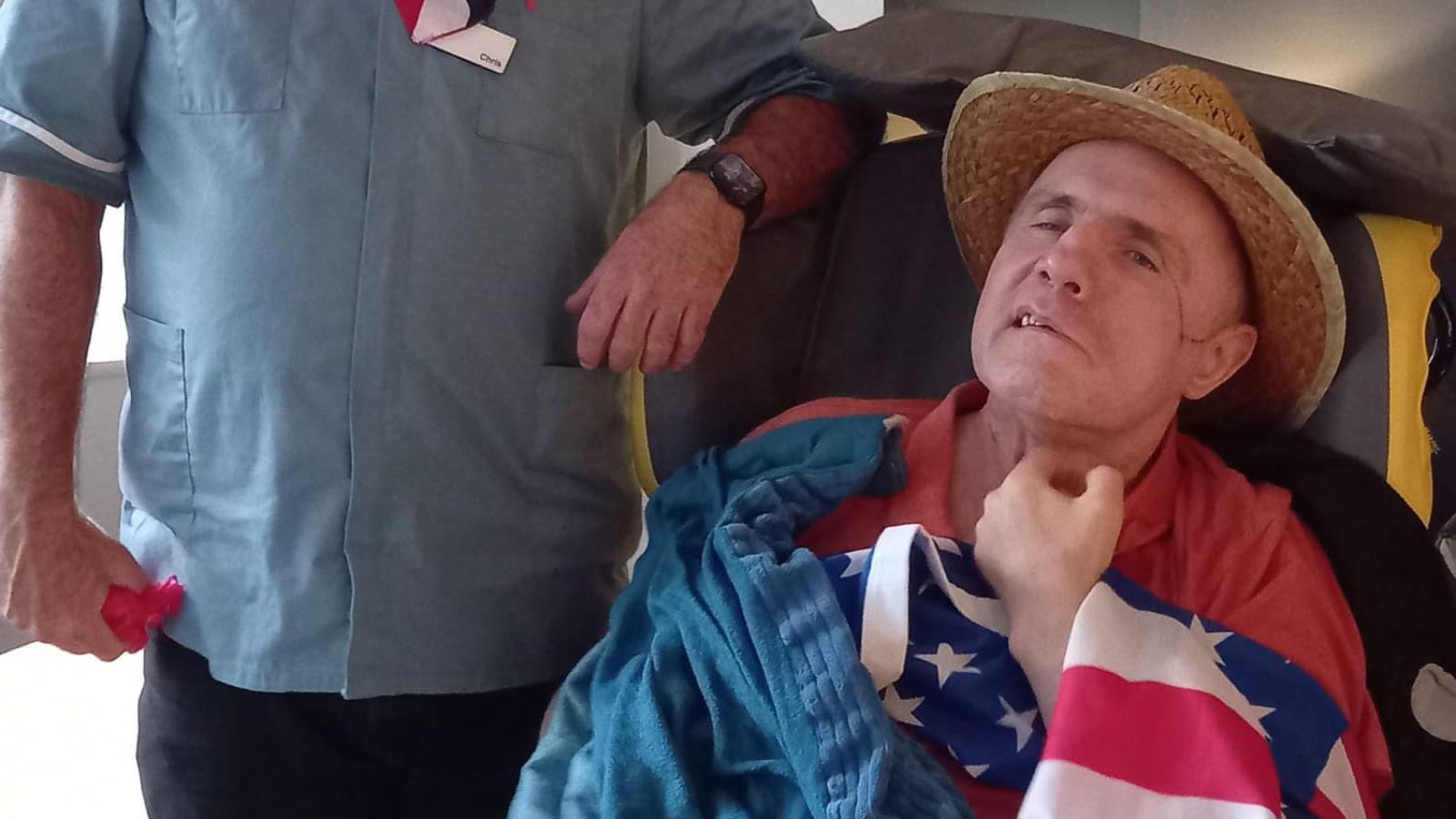 Two people wearing straw hats and an American flag