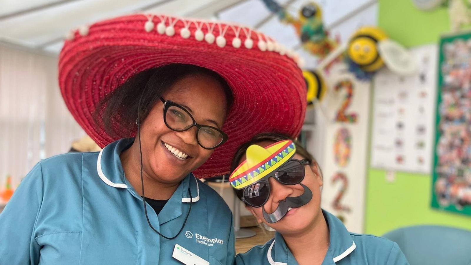 Two people wearing sombreros and funny glasses