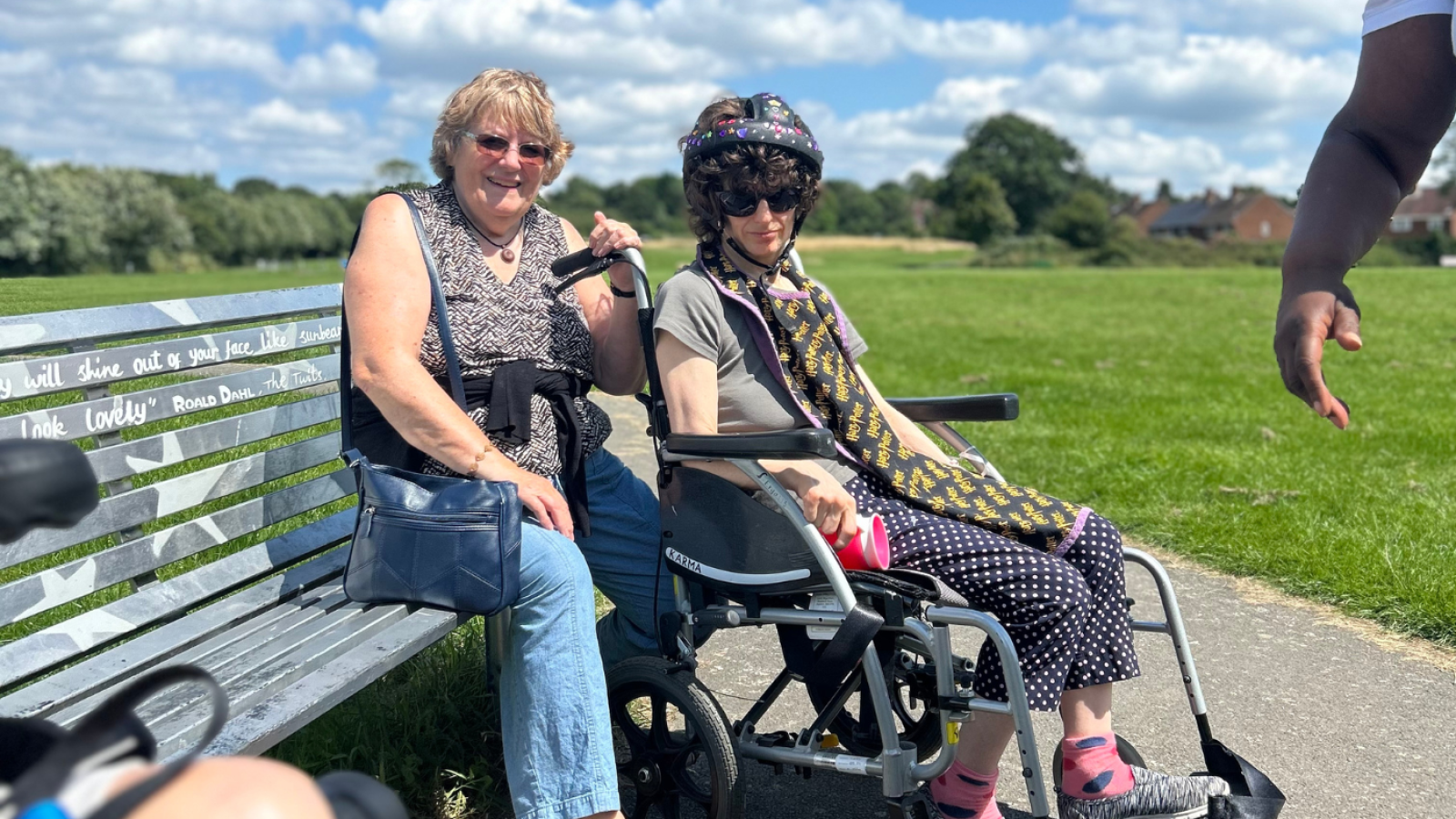 Two ladies sat in the sunshine, one lady is in a wheelchair