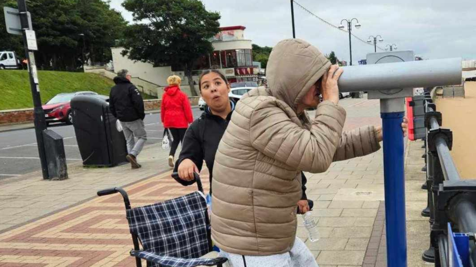 A person looking through binoculars at the seaside