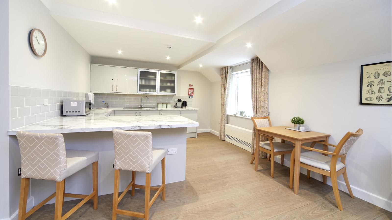 Dining room with kitchenette, bar table and stools and dining tables