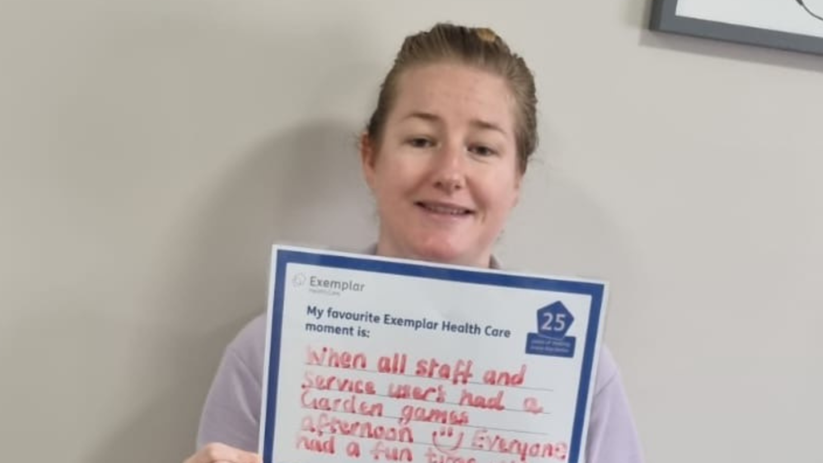 Colleague holding up a sign saying that her favourite moment is seeing people have fun in the garden