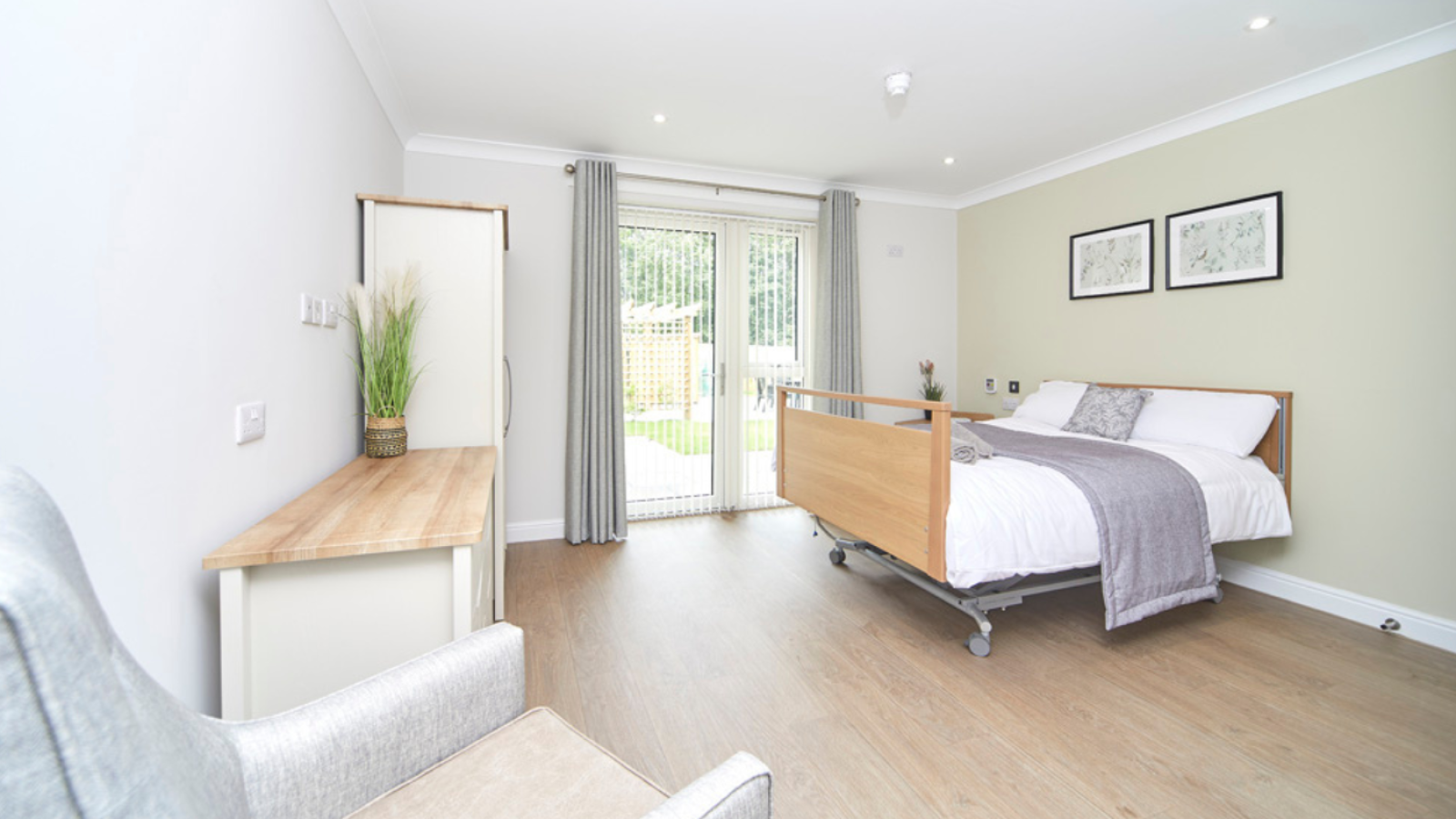 A photo of a bedroom with double doors leading into a garden, with furniture around the room