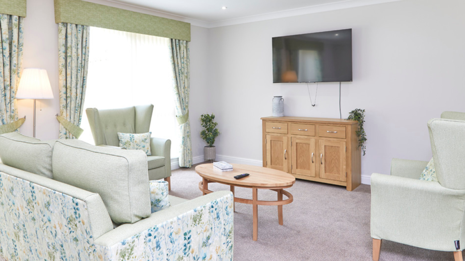 A lounge area with a large TV on the wall
