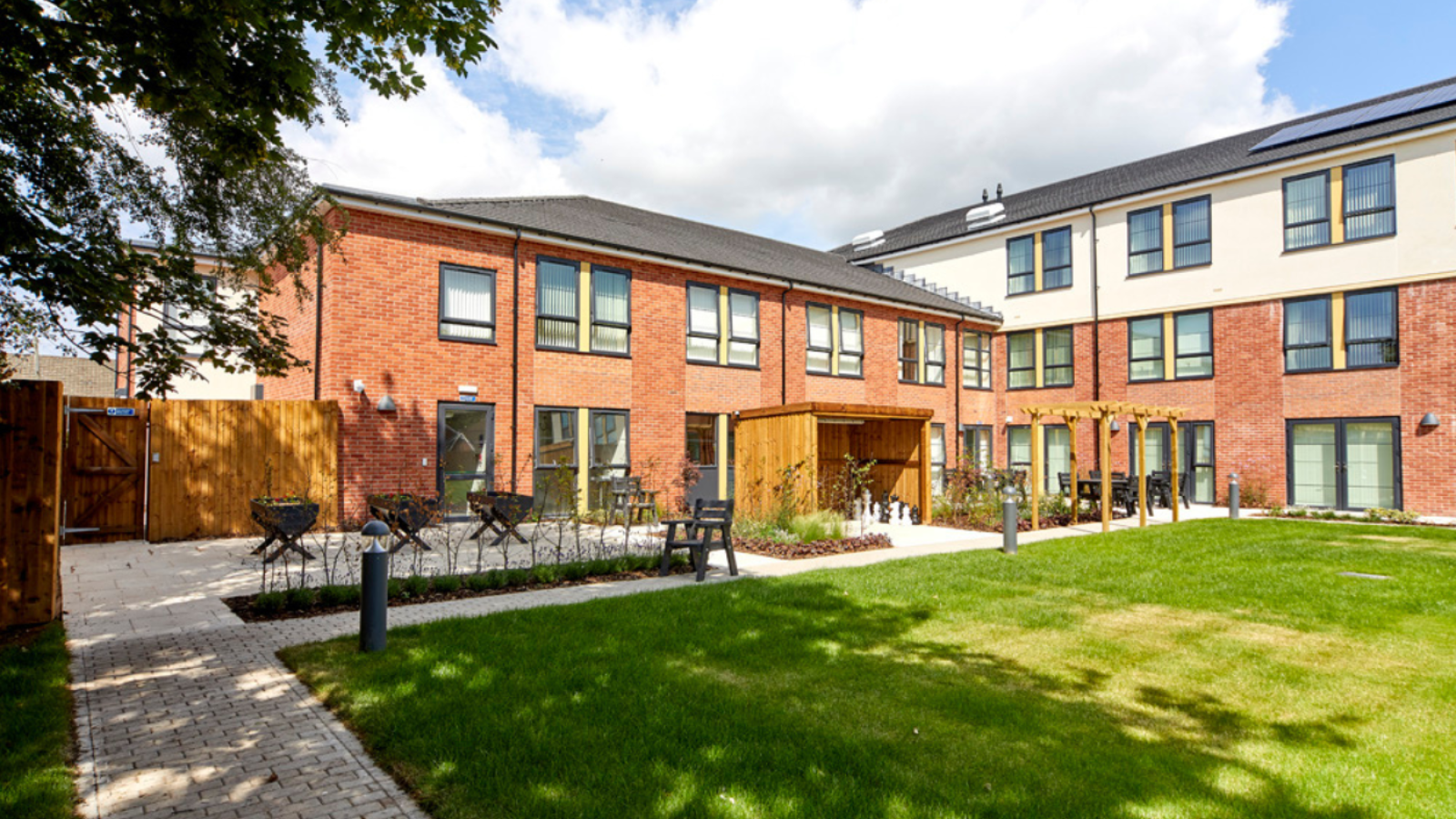 Three storey care home and a large garden with patio