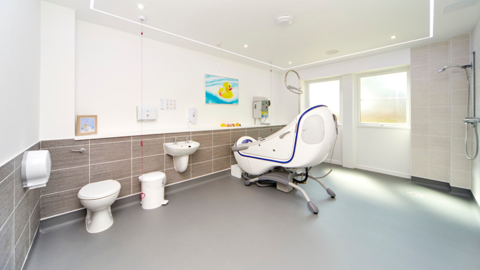 A wet room bathroom with whirl pool bath, toilet, sink and shower area