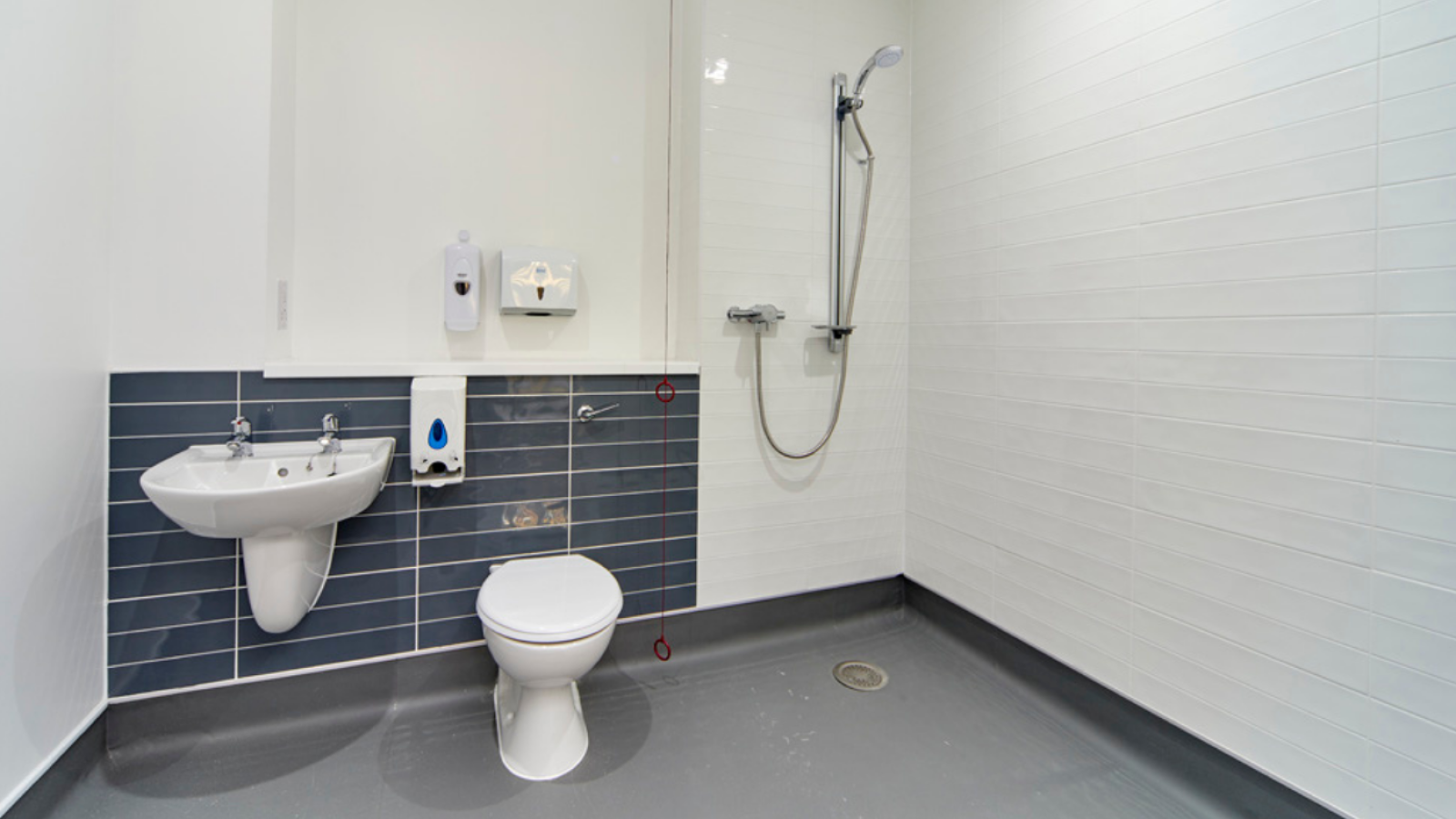 An en-suite wet room with sink, shower and toilet