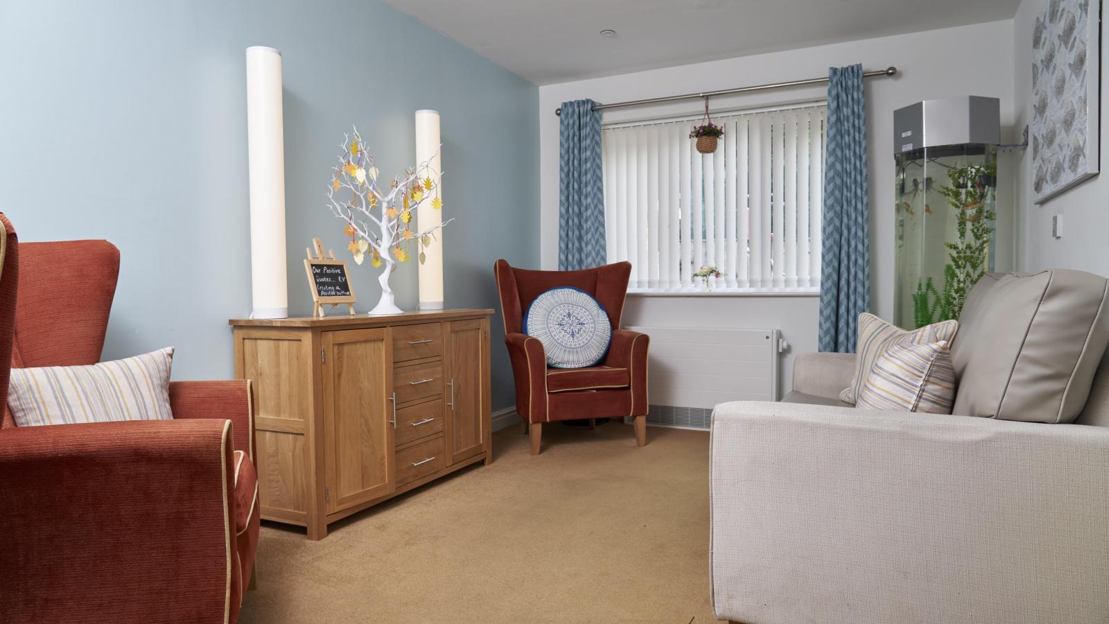 Quiet lounge area with a sofa and fish tank in the corner