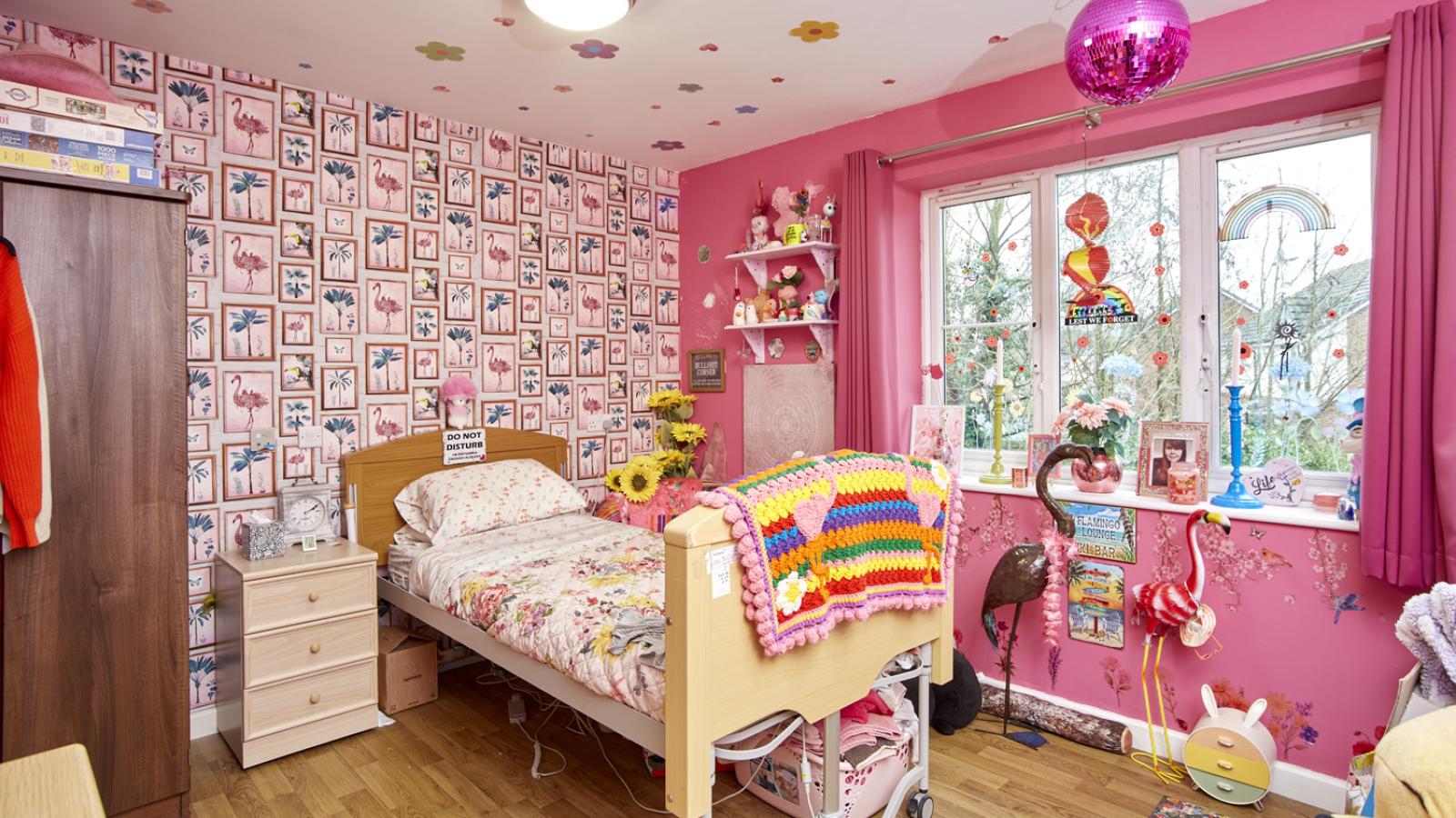 Bedroom decorated with bright pink decorations, with single bed and bed side table