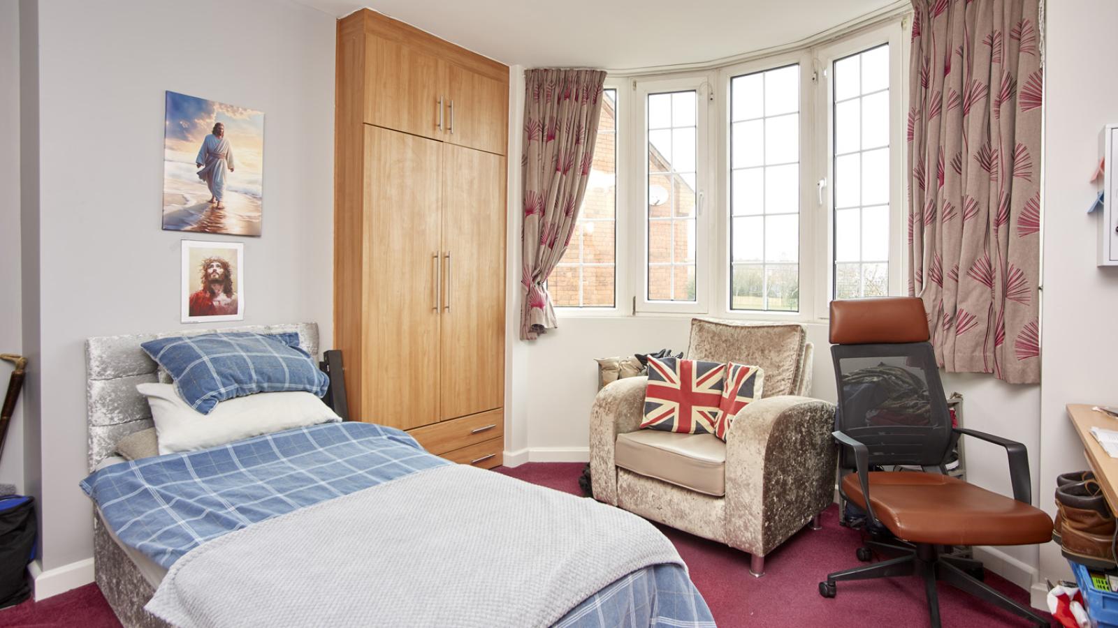 Bedroom setting with bed, chair, and wardrobe