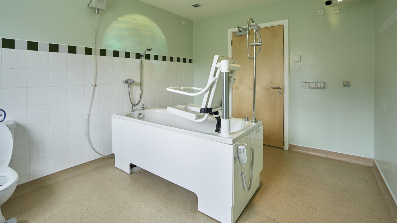 Bathroom with accessible bath and projector on wall