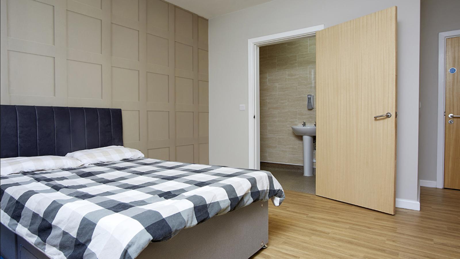 Bedroom with bed, and a door open to an en-suite