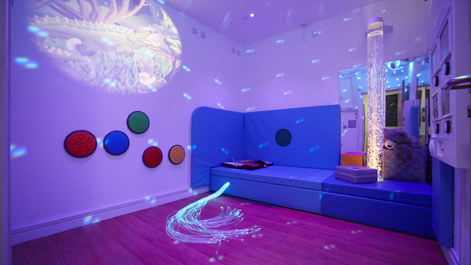Sensory room with projector, padded seating, and accessories