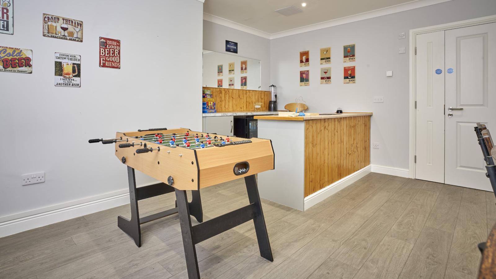 Pub setting with table football and a bar with drinks displayed behind