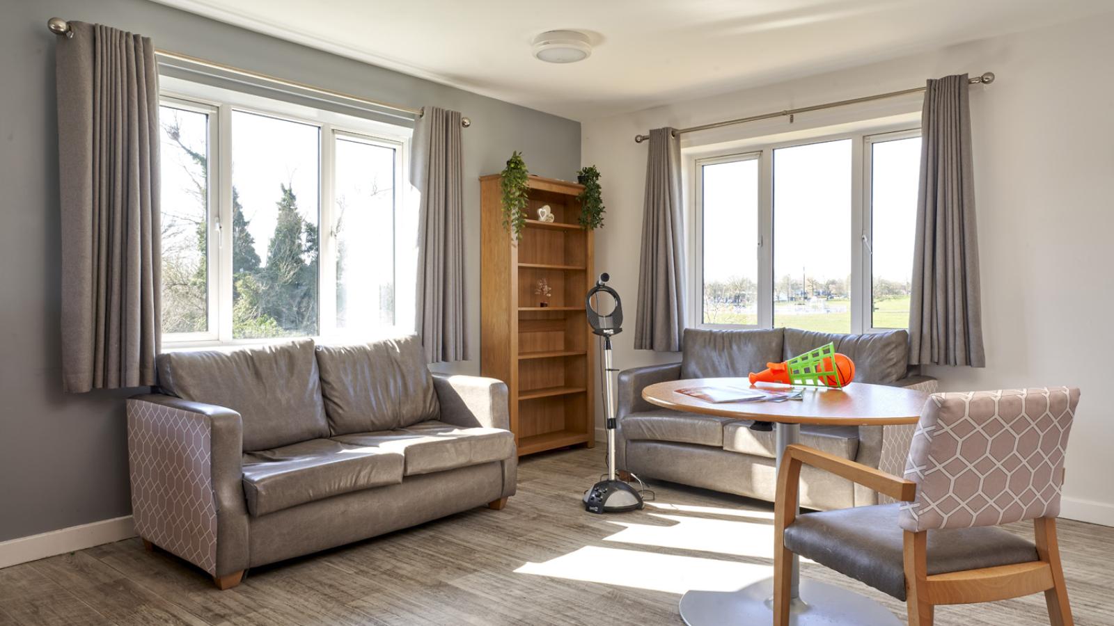 Lounge setting with a sofa and table with activities on, including a karaoke microphone stand