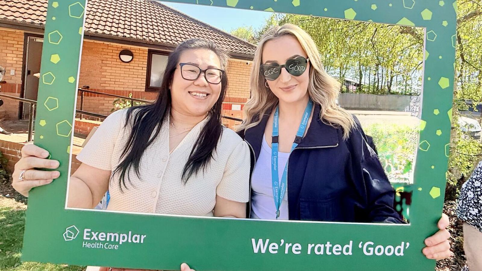 Two women smile within a green "Exemplar Health Care" frame that reads, "We’re rated ‘Good’." They appear cheerful under a sunny sky with trees in the background.