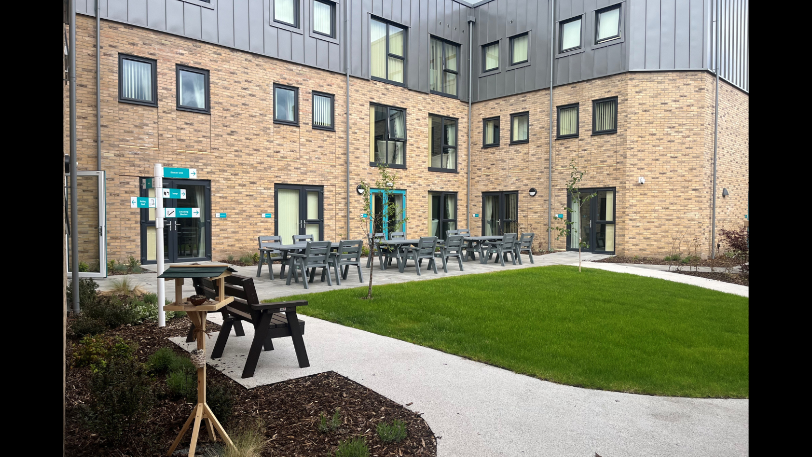 A courtyard featuring tables and chairs set up in front of a building, inviting for outdoor dining or relaxation.