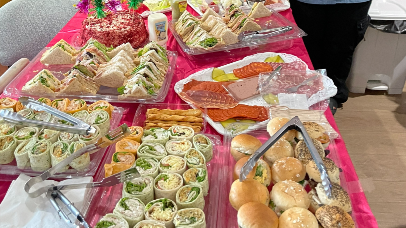 A table set with various sandwiches and an assortment of other food items.