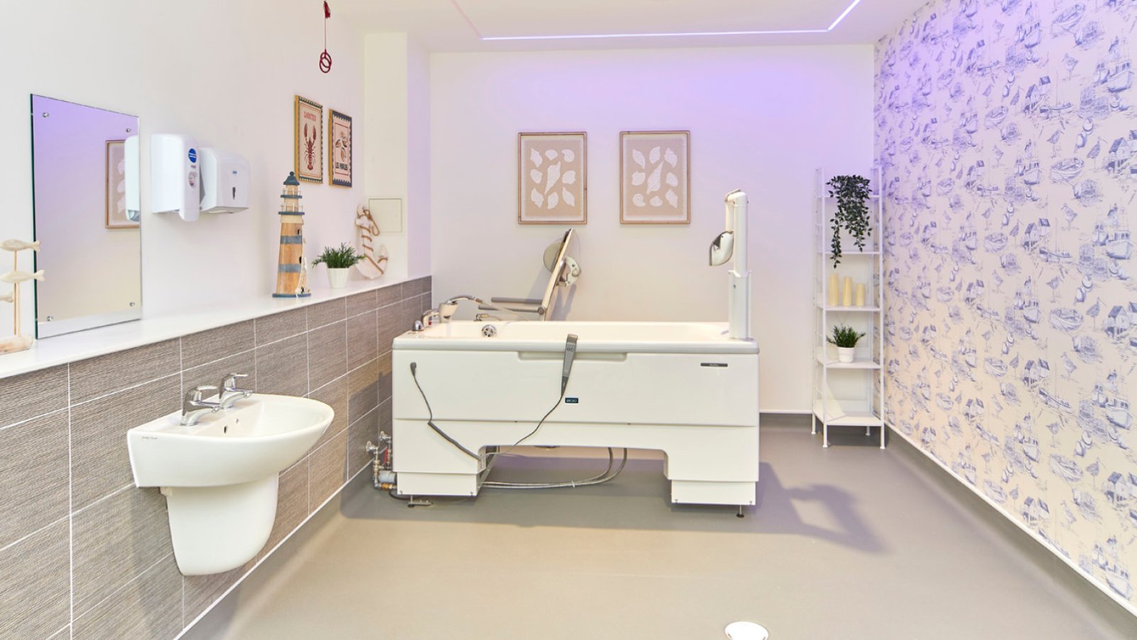 Bright modern spa bathroom with a therapeutic walk-in bathtub, wall-mounted sink, patterned accent wall, plants, and soft purple lighting.