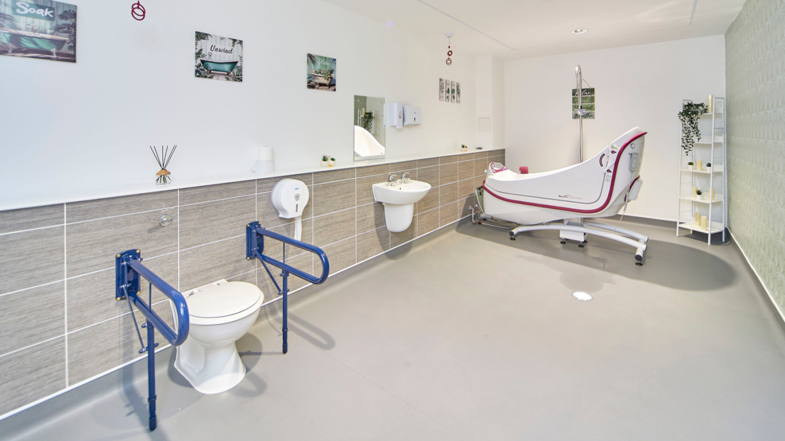 Bright, accessible bathroom with grab rails, raised toilet, sink, and hydro bathtub; clean, modern design creates a calm, welcoming space.